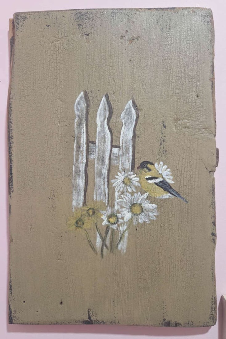Folk Art bird painting on wood: antique barnwood slab with vintage painting of a bird sitting on some flowers on a white picket fence roughly 11" wide by 16 1/2" high