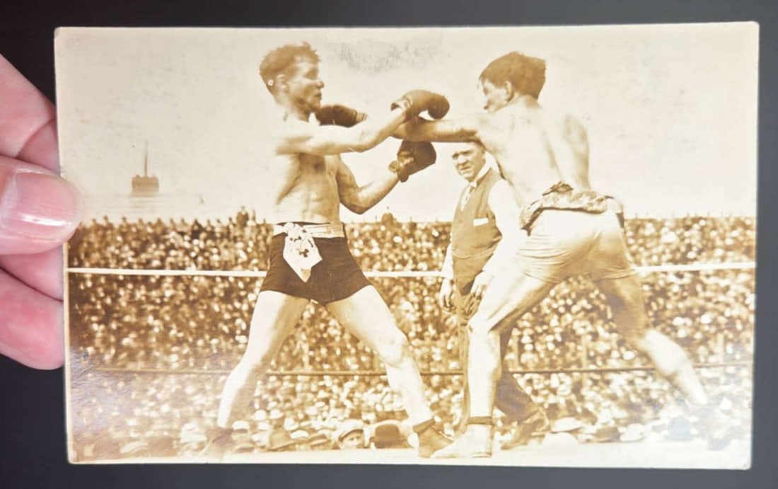 vintage publicity rppc pair of pugilists match: original vintage almost sepia toned real photo postcard with California maker's stamp of a pair of sparring boxers in an outdoor match and a referee in the background, no info on the back