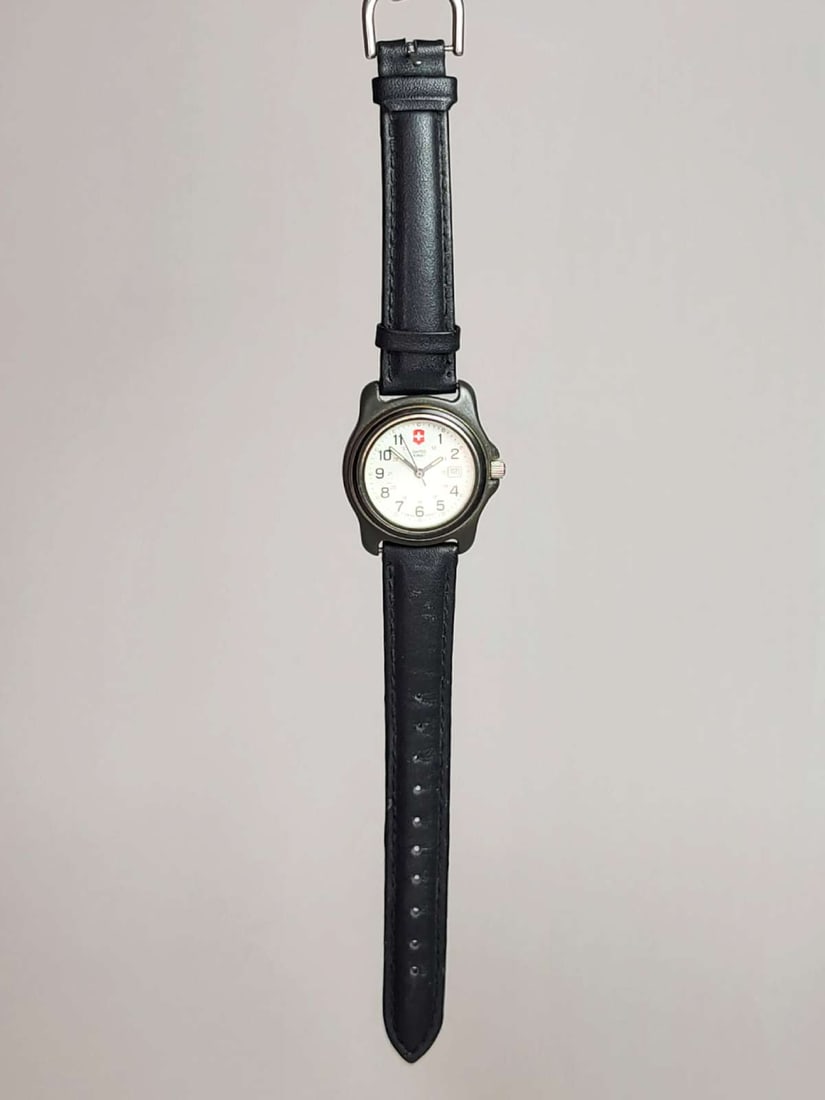 vintage estate jewelry: Swiss Army watch: vintage Victorinox wristwatch with newer black leather band and white dial with date window whole piece about 9" long, band width 5/8" and dial about 15/16"