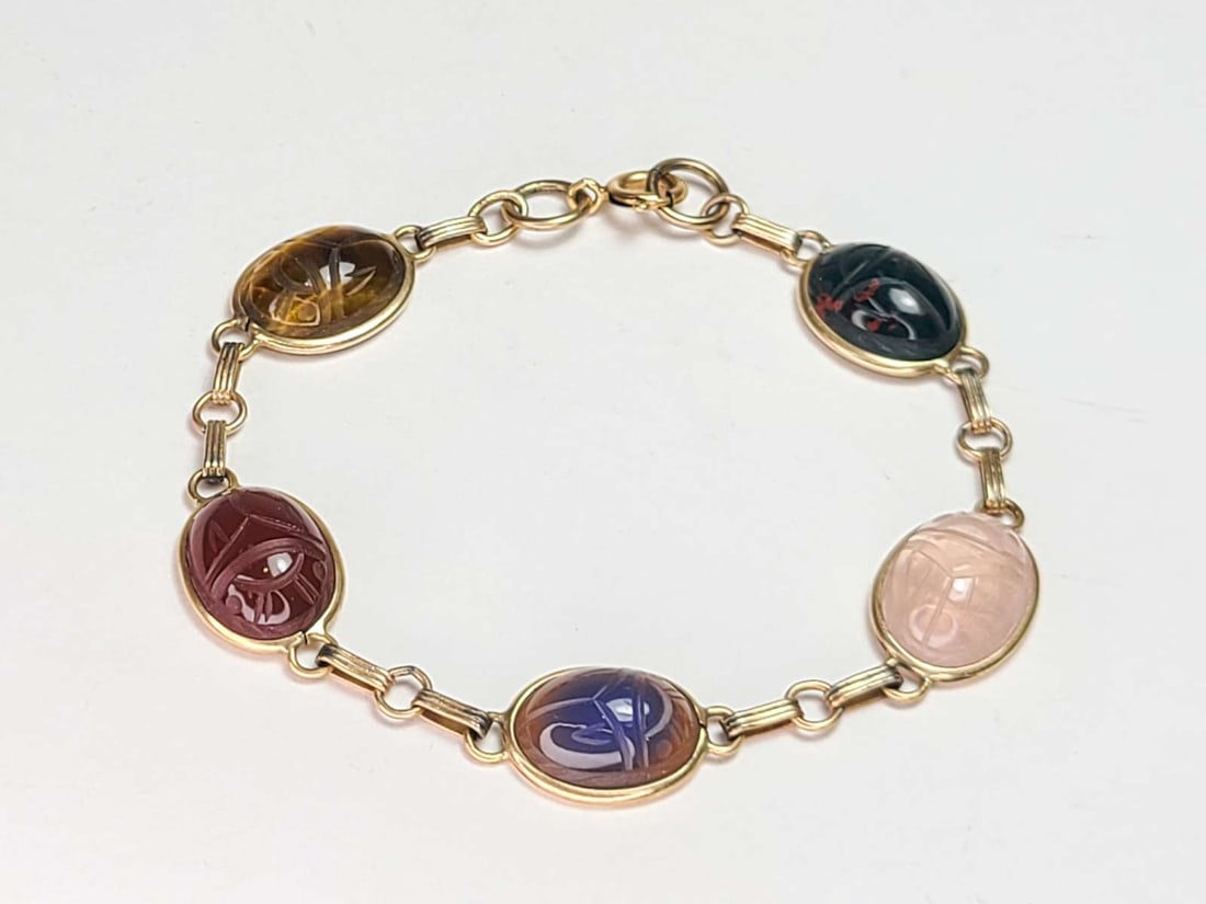vintage estate jewelry: gold gemstone bracelet: marked 14k gold filled bracelet with pink Quartz, Tiger's Eye, Jasper and other gemstone inset stones, carved like Scarabs about 2 3/4" inside diameter, scarabs in se