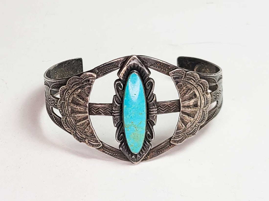 vintage estate jewelry: Native American bracelet: vintage Native American Indian cuff bracelet with mark for Sterling silver and Bell Trading Company (Fred Harvey era) and typical Southwest motifs of figures and feathers and central oblong Turquoise 