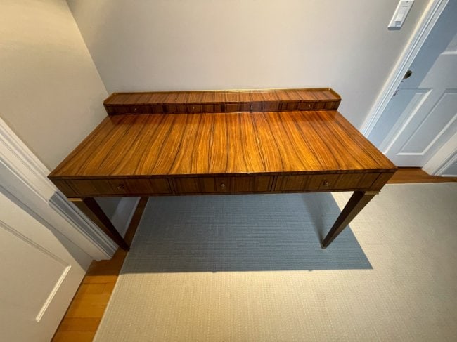 Modern History Veneered Tiger Wood Finish Gilt Gallery Desk: A beautiful desk with a fabulously veneered tiger wood finish having seven drawers with brass pulls and tapering legs that terminate on brass caps. The whole having a 3/4 gilt gallery and beautiful do