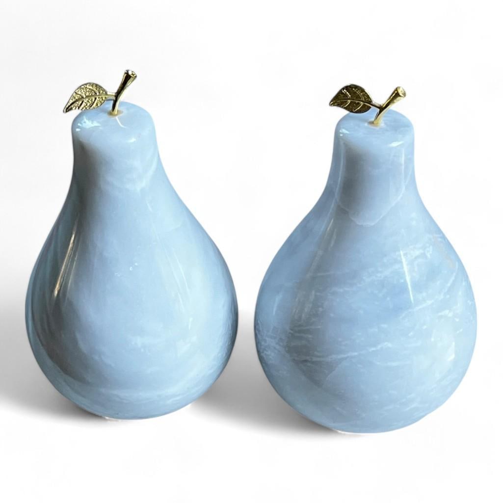 Pair of Solid Marble Pear Sculptures: Featuring a pair of solid marble pear sculptures, each meticulously hand-carved to capture the natural form of a pear. These versatile pieces can serve as elegant shelf decor or functional bookends. T