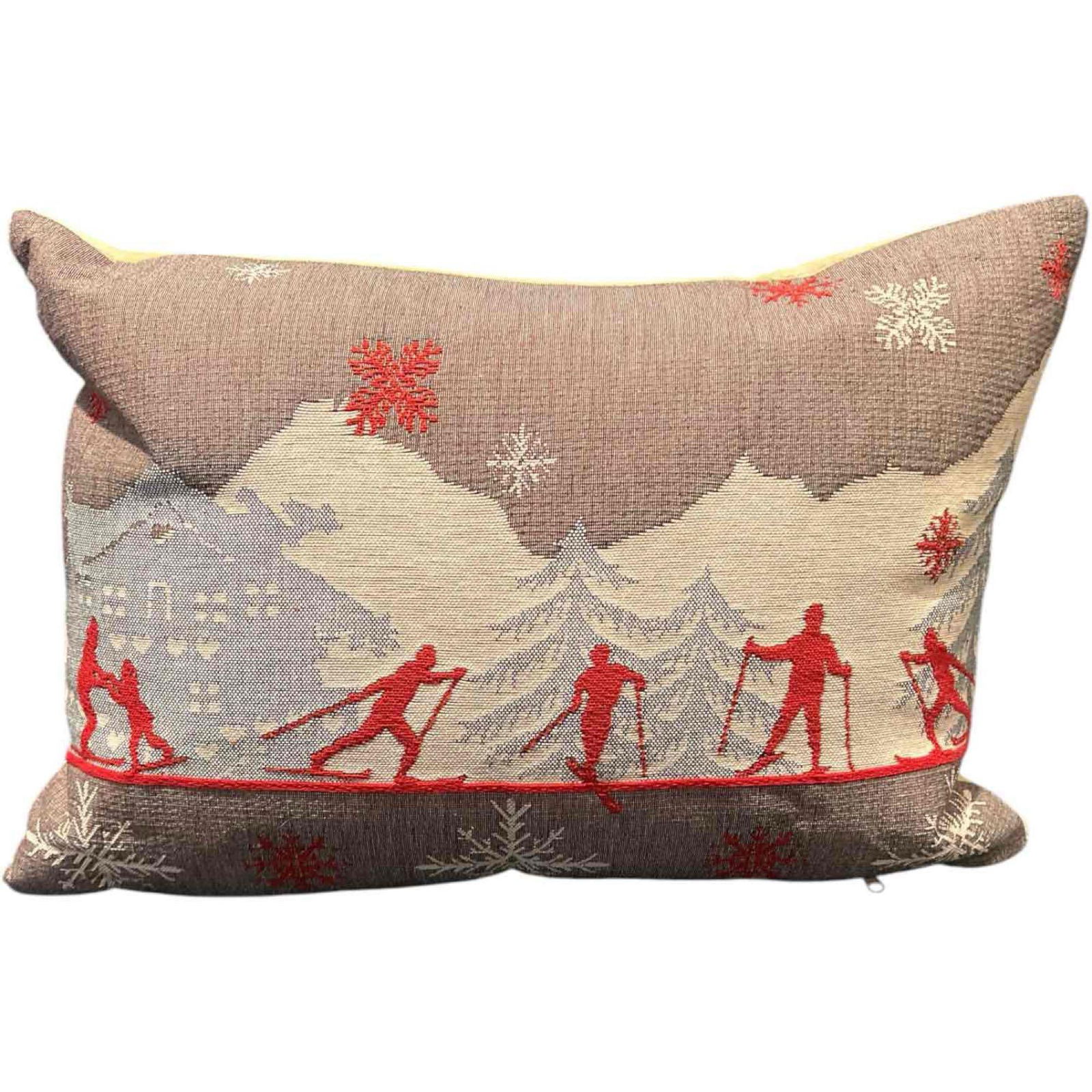 Rolande Du Dreuilh French Tapestry Pillow – Alpine Ski Scene: This Rolande Du Dreuilh woven tapestry pillow captures the essence of a classic Alpine ski village, featuring cross-country skiers and a chalet backdrop in a rich neutral and red color palette. Th