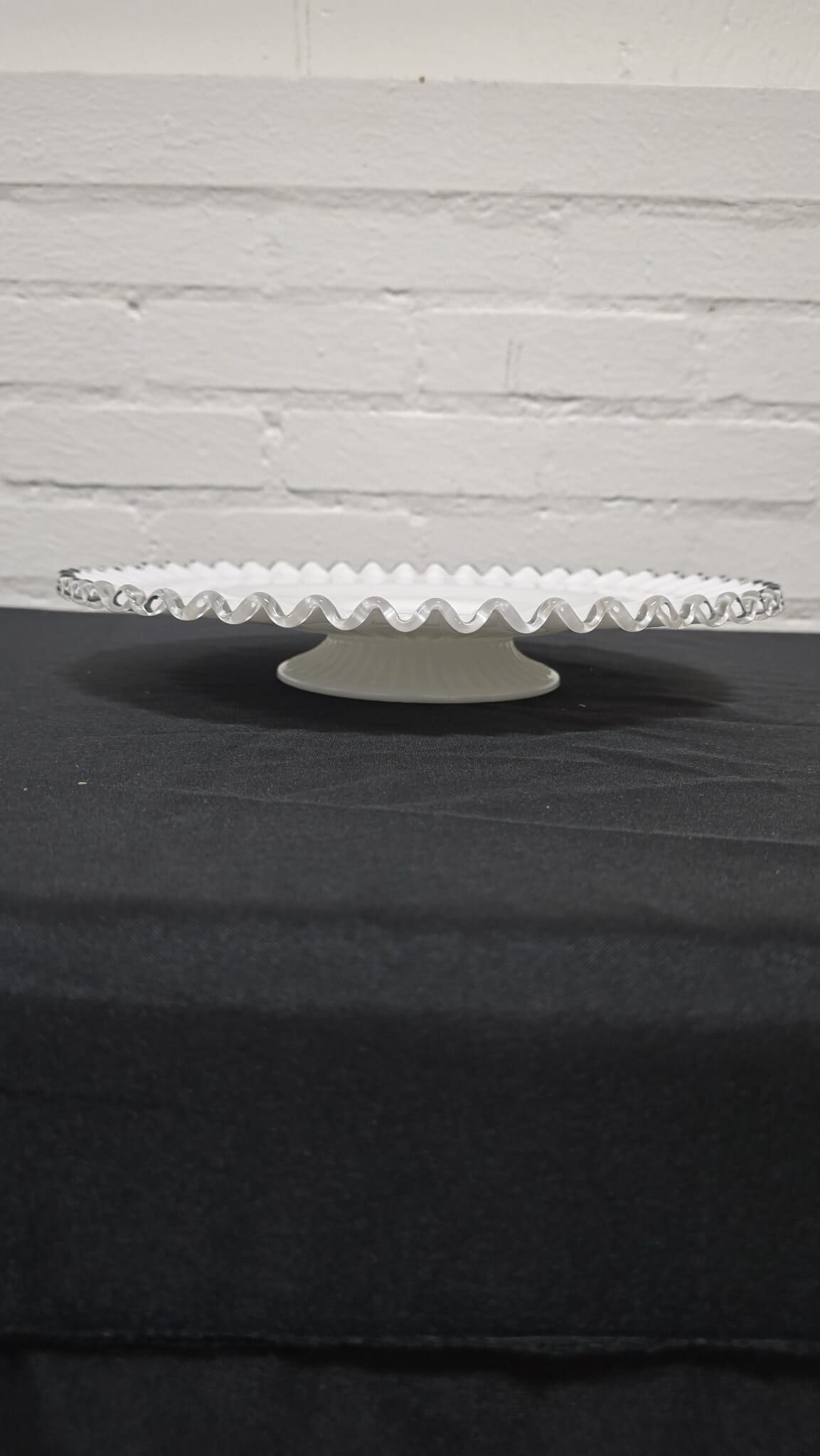 Vintage Milk Glass Silver Crest Low Cake Pedestal Stand: Classic white milk glass pedestal cake stand featuring a gently fluted surface and scalloped ruffled rim. The elevated pedestal base provides an elegant presentation, making this piece ideal for servi