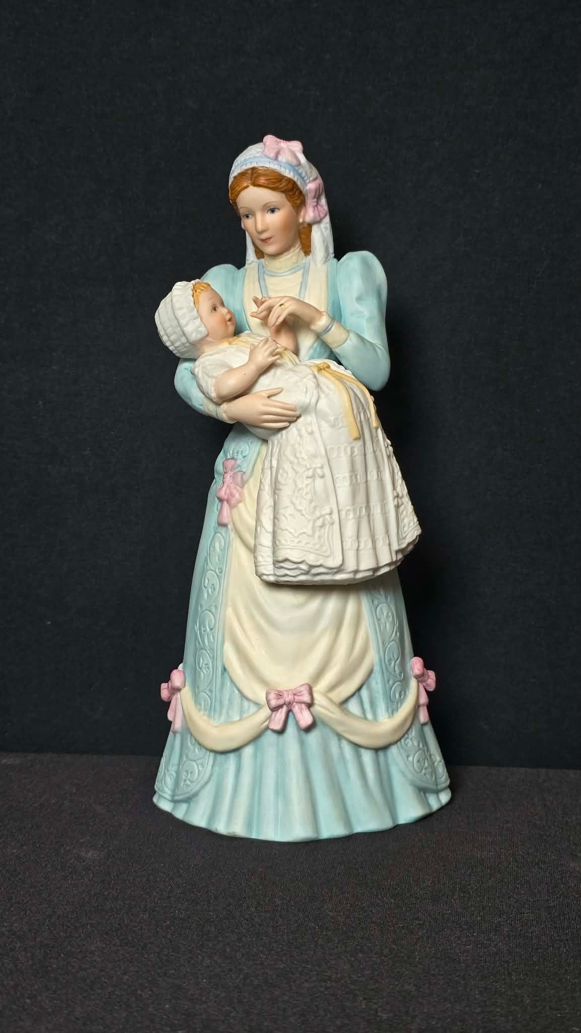 Lenox “The Christening” Fine Porcelain Figurine (1989): A fine porcelain figurine titled “The Christening” by Lenox, dated 1989. This tender scene depicts a mother holding an infant dressed in a traditional christening gown, rendered in soft