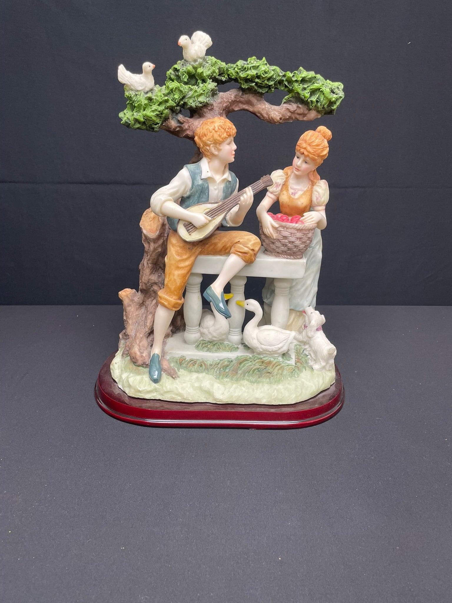 Sculpted Resin Couple: Sculpted resin couple, part of a statuette collection from the 1970s titled "The Monet Collection". It is a vintage collector's piece. It features a pastoral scene with sculpted birds, a dog, and