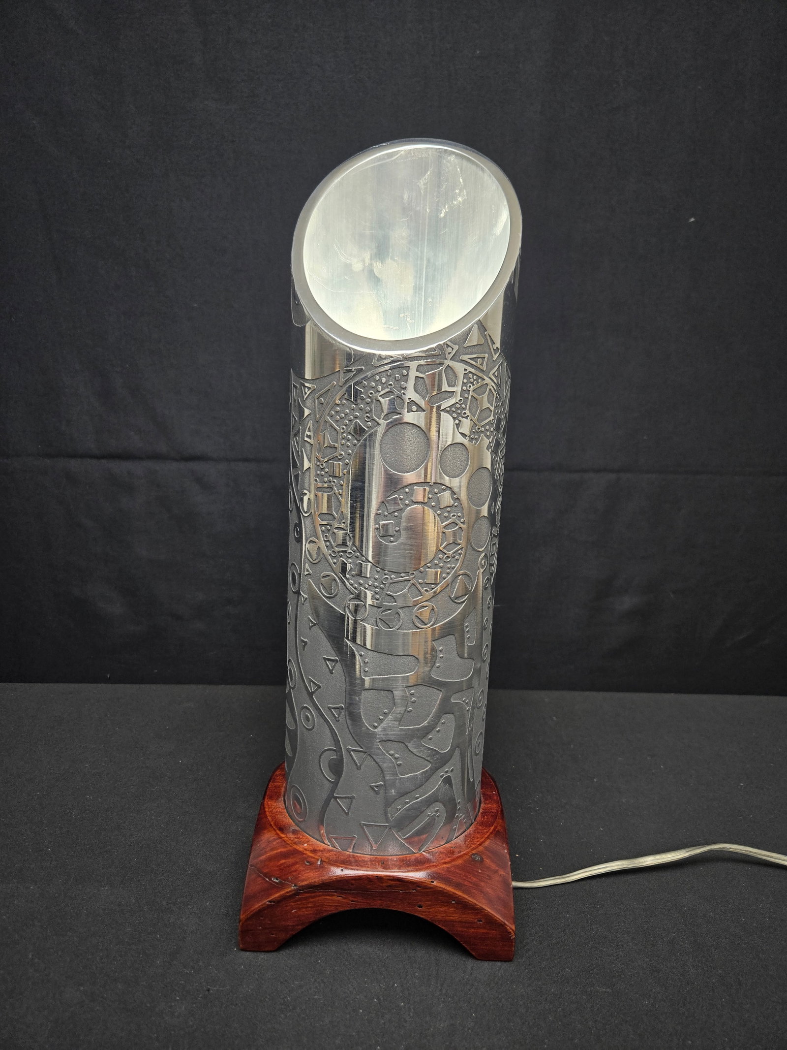 Jacob Rogins Aluminum Carved Lamp w/Wood Base: Jacob Rogins carved aluminum lamp shade with abstract geometric designs on a wooden pedestal base with a corded rotary switch operation.