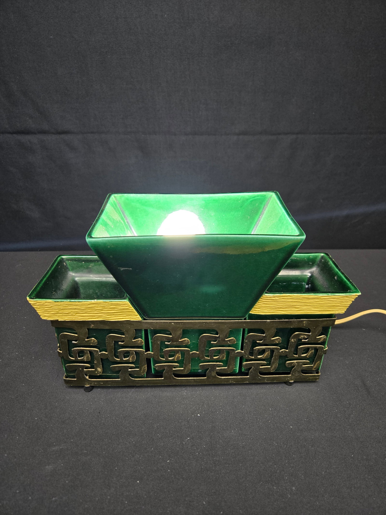 1952 Miramax TV Lamp and Planter: 1952 lamp in jade green ceramic with straw yellow detailing on the planters, held in a gold metallic shell. Operated by a flip switch on the back of the piece.
