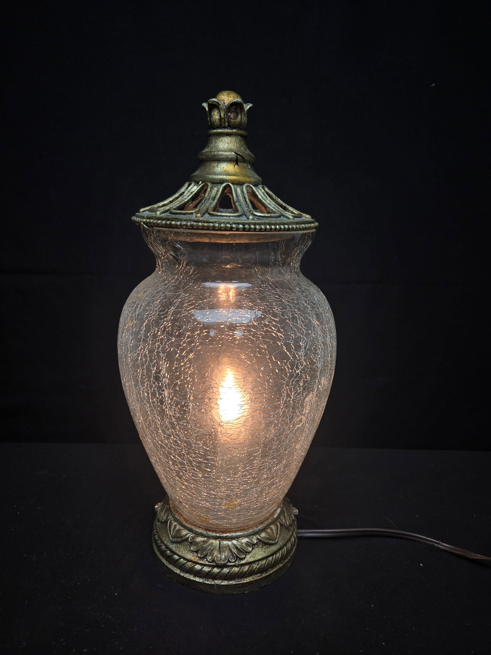 Crackled Glass Lamp: Crackled glass on an ornate carved resin base with a carved cut out lid and candle mimicking lightbulb, operated by a corded rotary switch.