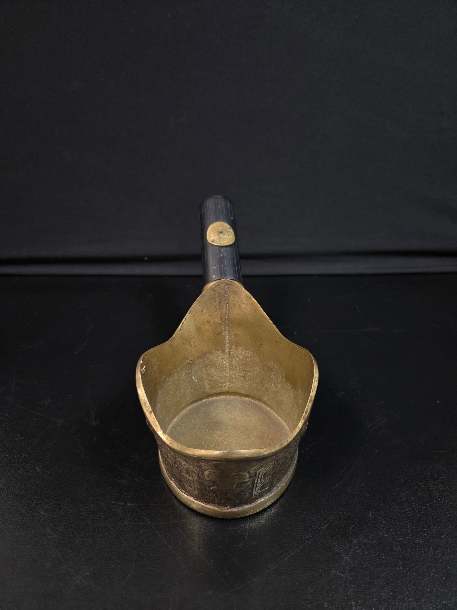 Antique Chinese Brass Silk Iron: Antique Chinese silk iron made of brass with sleek black wooden handle and intricate carvings.