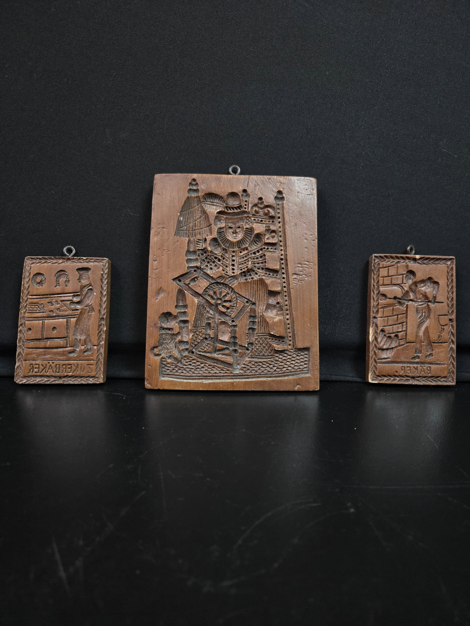 Springerle Cookie Molds Set of Three (3pc): Set of three springerle German cookie molds, each depicting a craftsman at work. The pastry chef or "zukerbäker", the baker or "bäker", and the Stuttgart spinner. Made as replicas by house on the