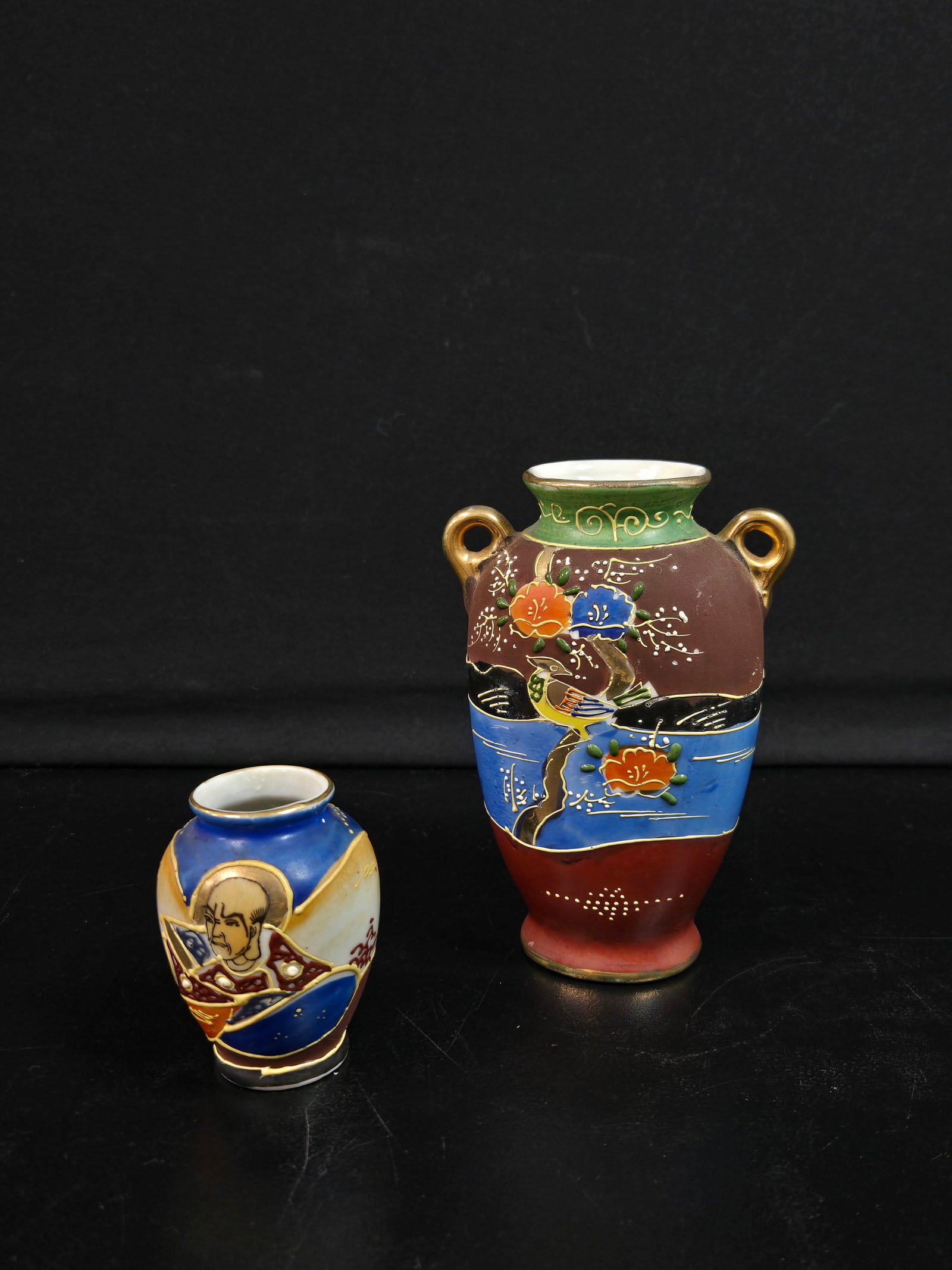 Set of Small Ceramic Vases (2pc): Two small ceramic vases in multiple colors. One depicts a bird surrounded by flowers on a branch. The other depicts a man surrounded by nature.