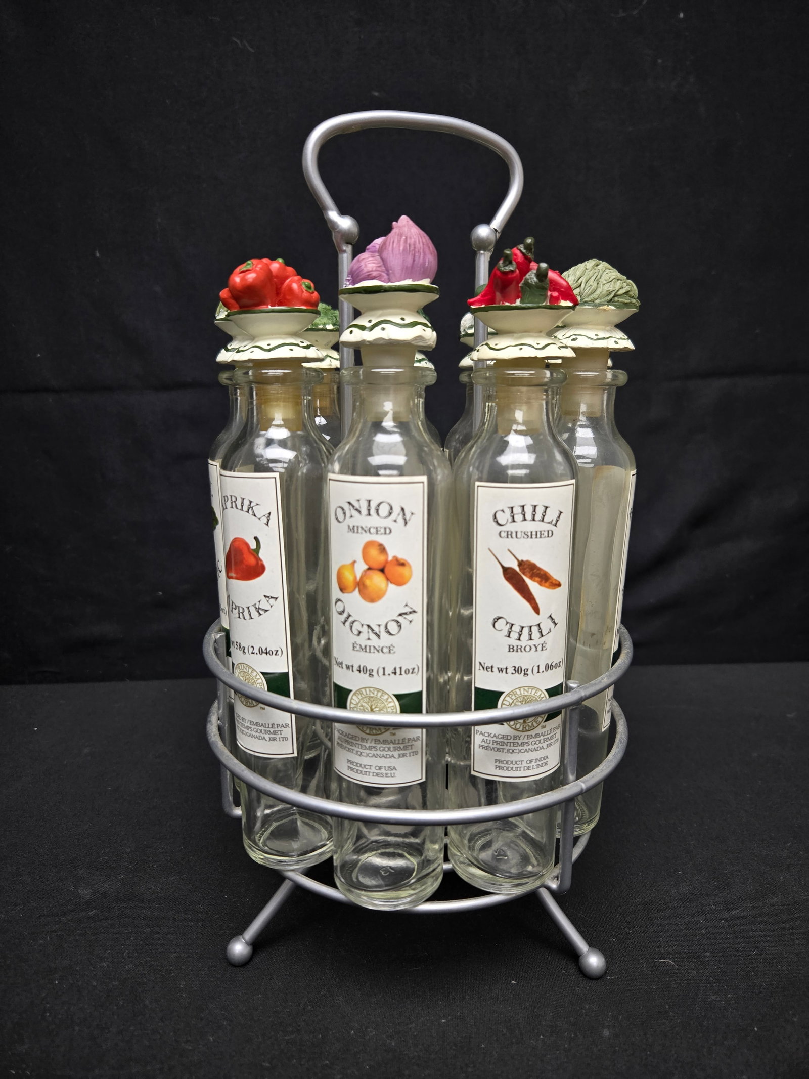 Nine Bottle Revolving Spice Rack (9pc): Revolving spice rack with nine corked bottles embellished with small statues of spices on lids.