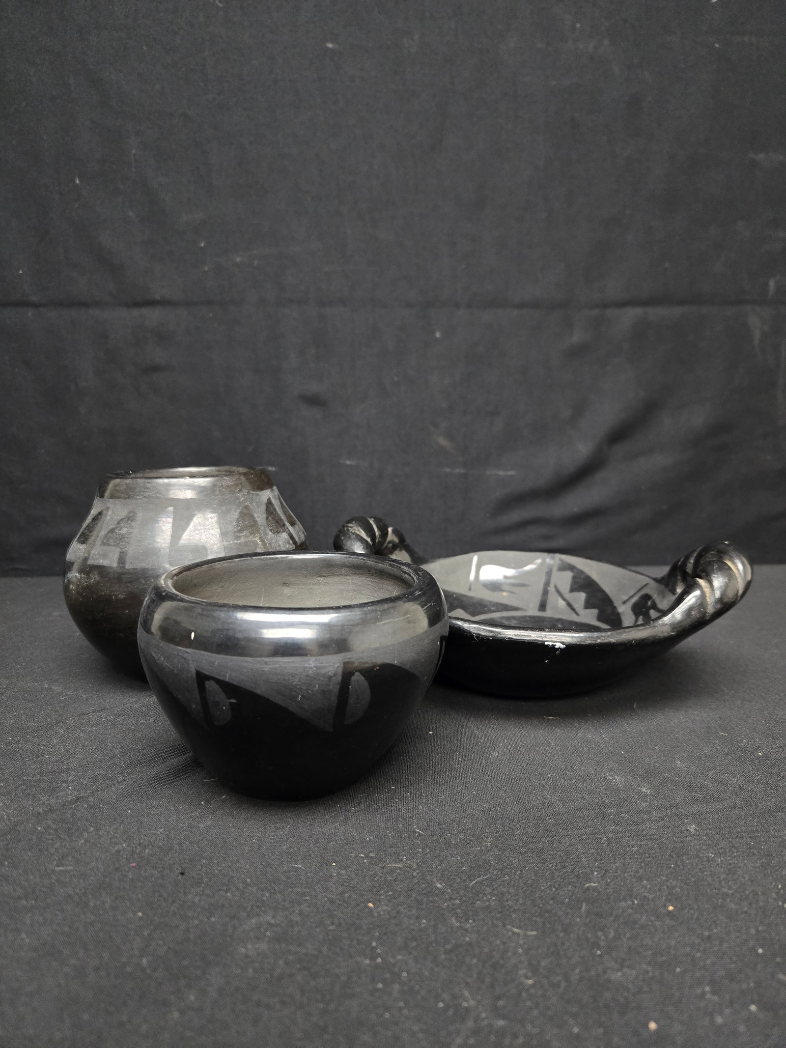 San Ildefonso Pueblo Black Ware Pottery Set (3pc): Set of three black pottery art pieces made in San Ildefonso Pueblo, New Mexico consisting of a bowl, tray, and small vase. Each piece features glazed geometric designs.
