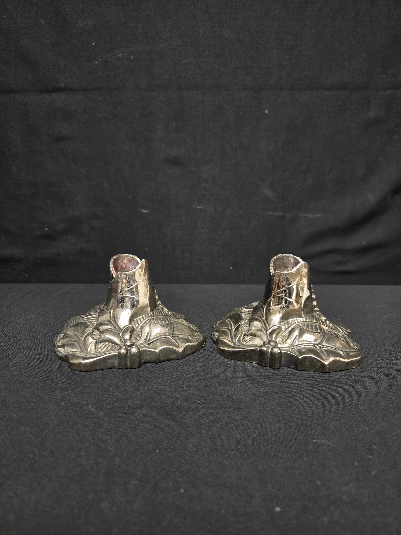 Pair of Silver Candleholders (2pc): Two small silver candleholders decorated with leaves and festive holly. Both have blue velvet on the bottoms.