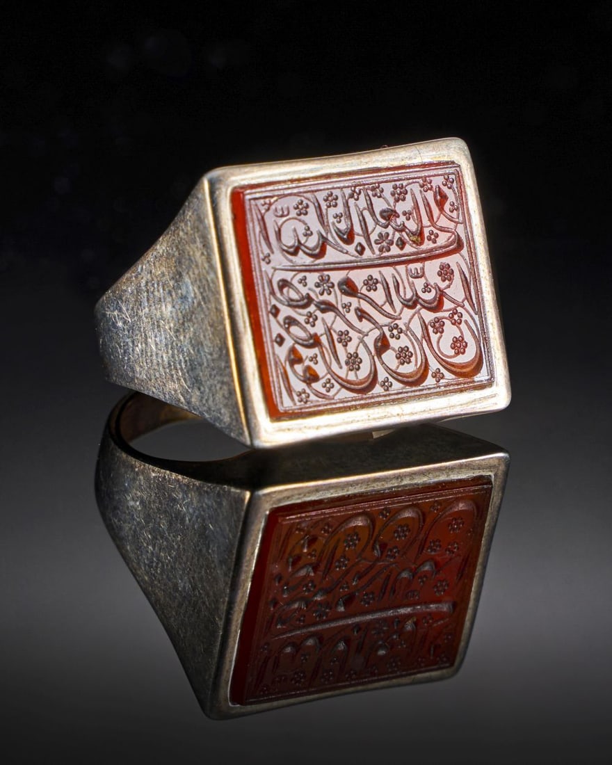 A CALLIGRAPHIC INSCRIBED CARNELIAN RING ON SILVER, 19TH CENTURY, PERSIA: A CALLIGRAPHIC INSCRIBED CARNELIAN RING ON SILVER, 19TH CENTURY, PERSIA Length of Gem: 1.7cm Weight: 7.8g Internal Diameter: 1.8cm