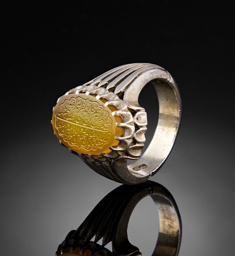 A CALLIGRAPHIC INSCRIBED CARNELIAN RING, 19TH CENTURY, PERSIA: Lot 153. A CALLIGRAPHIC INSCRIBED CARNELIAN RING, 19TH CENTURY, PERSIA This 19th-century Persian ring features an oval carnelian bezel finely engraved with Arabic calligraphy. The in