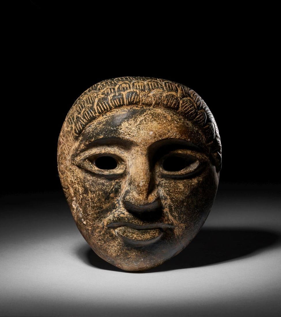 A CARVED BLACK STONE MASK OF AN AKKADIAN (1 of 4)