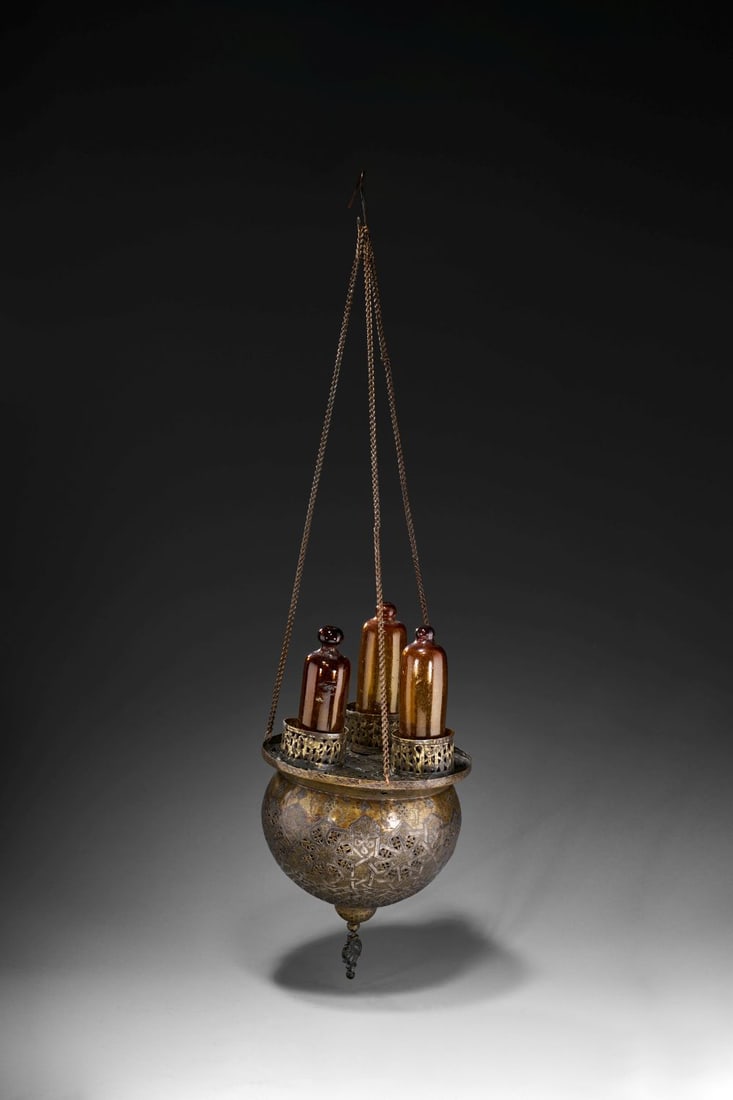 A SILVER INLAID MAMLUK REVIVAL BRASS HANGING LANTERN, TURKEY OR SYRIA, 19TH CENTURY: Lot 293. A SILVER-INLAID MAMLUK REVIVAL BRASS HANGING LANTERN Turkey or Syria, 19th Century Formed as a suspended spherical lantern with a broad pierced collar, the vessel is crafted from brass with