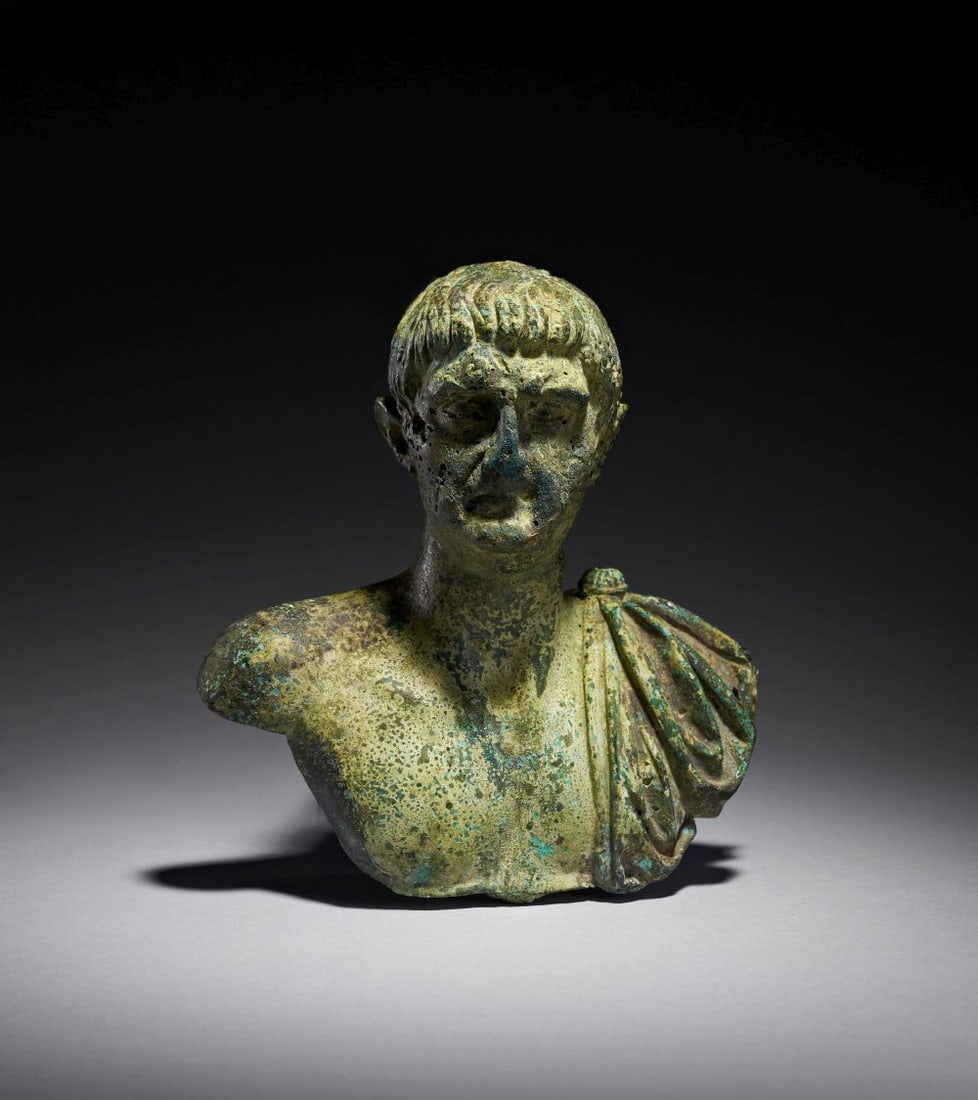 A ROMAN BRONZE PORTRAIT BUST OF THE EMPEROR TRAJAN TRAJANIC PERIOD, REIGN 98-117 A.D.: A ROMAN BRONZE PORTRAIT BUST OF THE EMPEROR TRAJAN TRAJANIC PERIOD, REIGN 98–117 A.D. Finely cast in bronze, this compelling portrait bust represents the Emperor Trajan, one of Rome’s mos