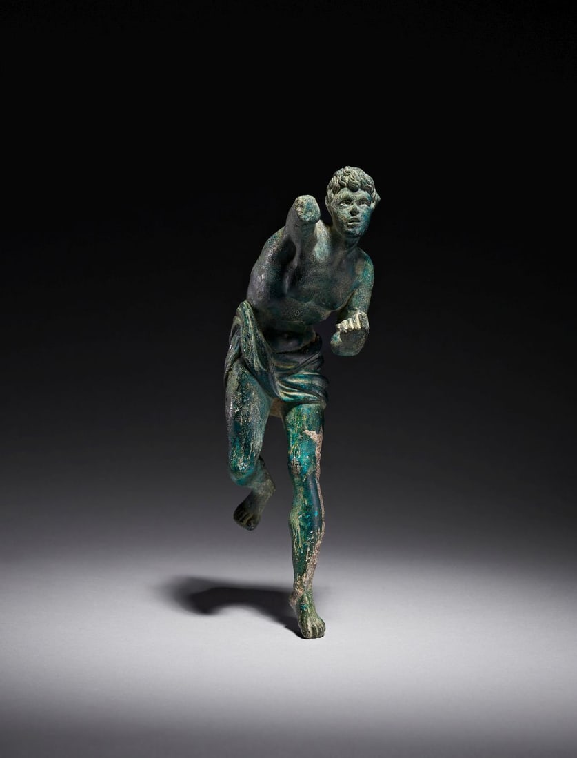 A GREEK BRONZE FIGURINE OF AN ANTHLETE, CLASSICAL PERIOD, CIRCA 450-400 B.C.: A GREEK BRONZE FIGURINE OF AN ATHLETE, CLASSICAL PERIOD, CIRCA 450–400 B.C. Cast in solid bronze and preserving a richly variegated surface of deep olive and malachite-green patination, this f