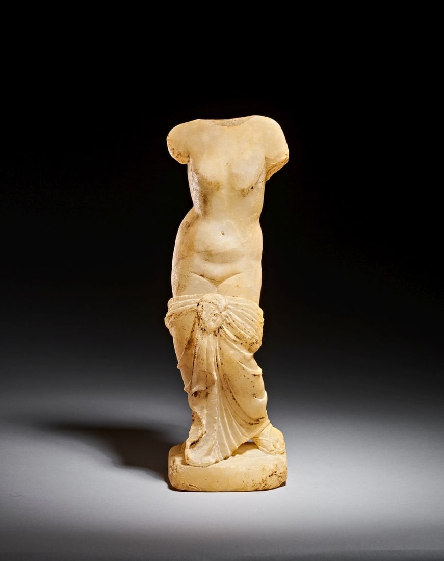 A ROMAN MARBLE VENUS CIRCA 1ST-2ND CENTURY A.D.: A ROMAN MARBLE VENUS Carved in luminous pale marble, this Roman figure of Venus is a compelling fragment of the classical tradition, capturing the goddess in an elegant, idealised nude form. The tor