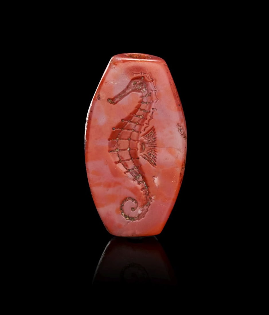A MINOAN STAMP SEAL DEPICTING A SEA HORSE, MIDDLE MINOAN I, CIRCA 2160-1800 B.C.: A MINOAN BANDED AGATE STAMP SEAL DEPICTING A SEA HORSE MIDDLE MINOAN I, CIRCA 2160–1800 B.C. Carved in banded agate of warm reddish-orange tone with areas of soft translucency and natura