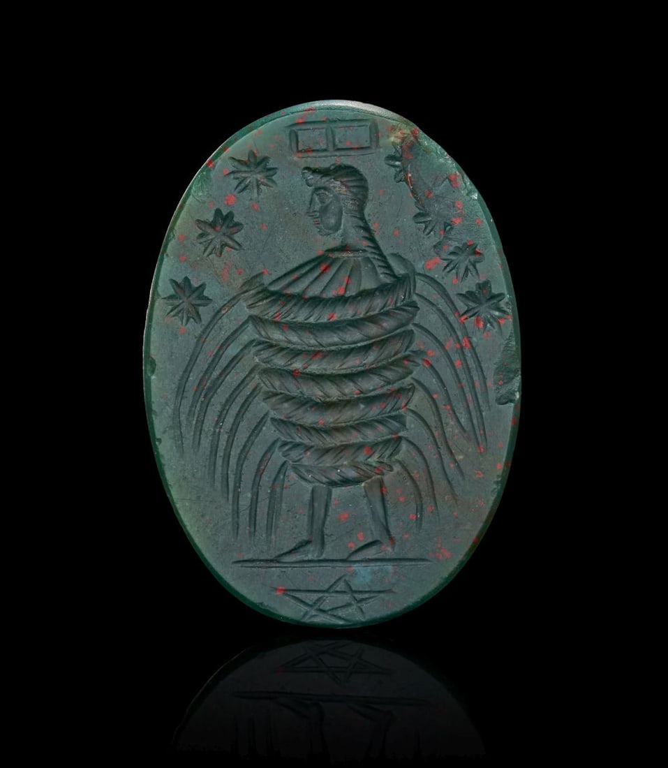 A LATE ROMAN BLOODSTONE MAGICAL INTAGLIO, ENGRAVED WITH A FEMALE FIGURE SURROUNDED BY ASTRAL SYMBOLS (1 of 3)