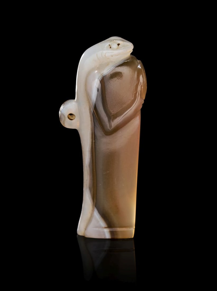 A RARE EGYPTIAN BANDED AGATE GECKO AMULET WITH INSCRIBED WEDJAT-EYE NEW KINGDOM, DYNASTY XIX, CIRCA:  AN EGYPTIAN BANDED AGATE GECKO AMULET WITH INSCRIBED WEDJAT-EYE NEW KINGDOM, DYNASTY XIX, CIRCA 1279–1212 B.C. Carved in banded agate of honey-brown and milky white tones wit