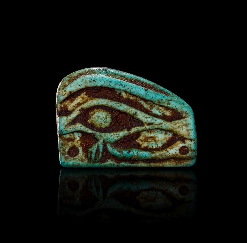 AN EGYPTIAN FAIENCE WEDJAT-EYE AMULET LATE PERIOD, DYNASTY XXVI-XXX, 664-343 B.C. (1 of 2)
