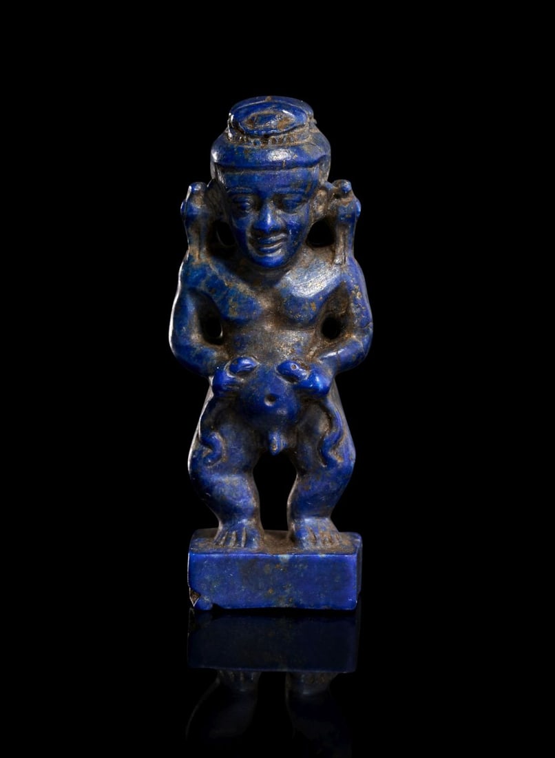 A HIGHLY RARE EGYPTIAN LAPIS LAZULI AMULET DEPICTING PTAIKOS, NEW KINGDOM DYNASTY XIX-XX, 1307-1070: A Highly Rare Egyptian Lapis Lazuli Amulet Depicting Ptaikos, New Kingdom Dynasty XIX–XX (1307–1070 BC) This striking amulet is carved from deep, vivid lapis lazuli and represents Ptaiko