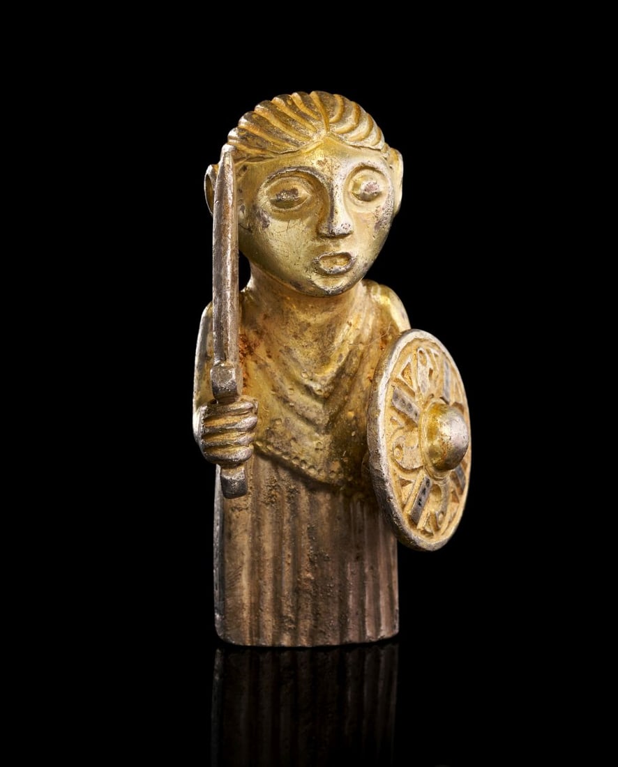 AN EXCEEDINGLY RARE VIKING VALKYRIE OF HARBY GILDED SILVER FIGURINE, CIRCA 8TH/9TH CENTURY A.D.: AN EXCEEDINGLY RARE VIKING VALKYRIE OF HARBY GILDED SILVER FIGURINE CIRCA 8TH/9TH CENTURY A.D. Finely cast in silver and richly gilded, this exceedingly rare Viking valkyrie figurine represents one o