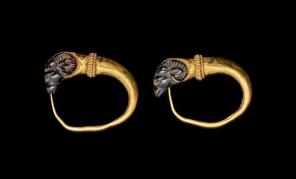 A PAIR OF ROMAN GOLD & GARNET RAM HEAD EAR RINGS, CIRCA 1ST-2ND CENTURY A.D.: A PAIR OF ROMAN GOLD & GARNET RAM HEAD EAR RINGS, CIRCA 1ST–2ND CENTURY A.D. Finely modelled in high-karat gold, this striking pair of Roman earrings terminates in sculpted ram’s hea
