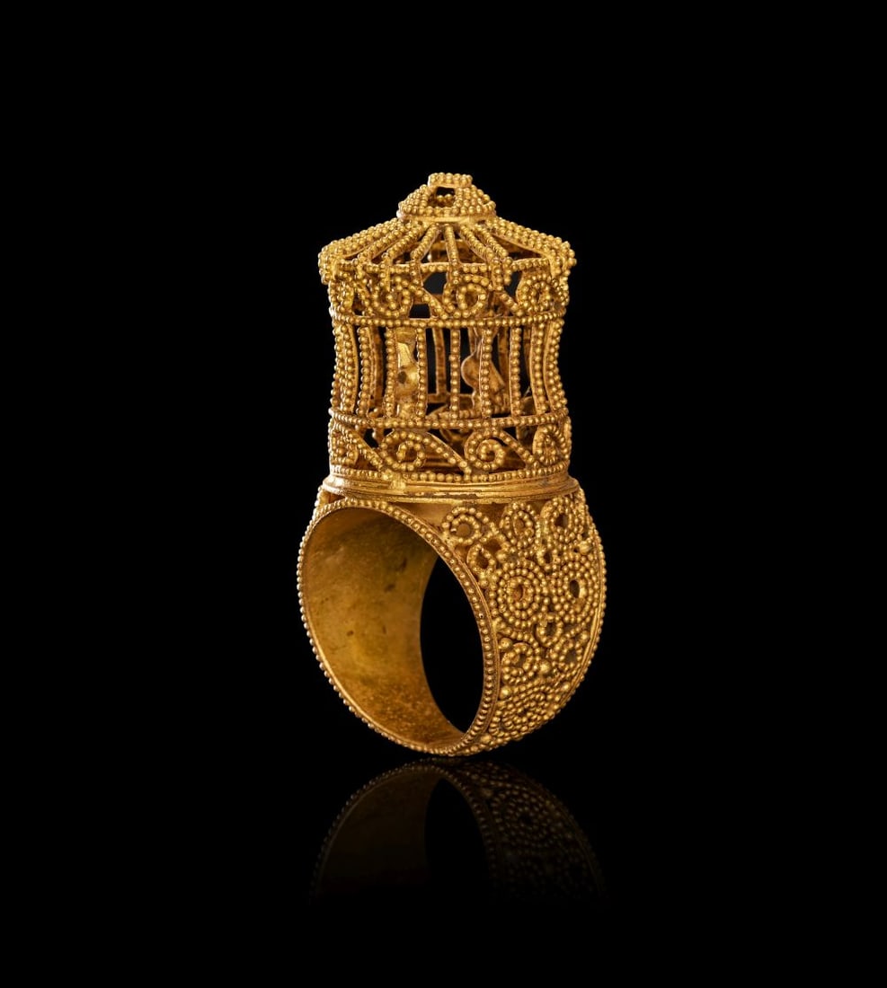 AN EXCEEDINGLY RARE BYZANTINE GOLD FILIGREE RING WITH A PAIR OF ENCASED BIRDS, CIRCA 7TH CENTURY A.D: A BYZANTINE GOLD FILIGREE RING WITH A PAIR OF ENCASED BIRDS, CIRCA 7TH CENTURY A.D. A superb and unusually ambitious gold ring, formed with a broad circular hoop rising to an architectural, lantern-