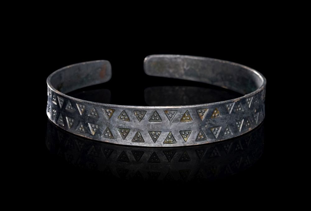 A VIKING SILVER BRACELET, CIRCA 9TH-10TH CENTURY A.D.: A VIKING SILVER BRACELET, CIRCA 9TH–10TH CENTURY A.D. Formed from a broad strip of silver and left open at the rear, this Viking bracelet is defined by its clean crescent profile and confident