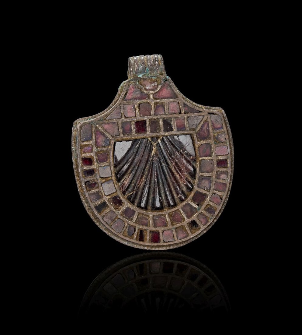A MEROVINGIAN SILVER AND GARNET APPLIQUE PENDANT, CIRCA 5TH-6TH CENTURY A.D.: A MEROVINGIAN SILVER AND GARNET APPLIQUÉ PENDANT, CIRCA 5TH–6TH CENTURY A.D. This finely preserved Merovingian silver appliqué pendant is formed in a broad, shield-like outline,