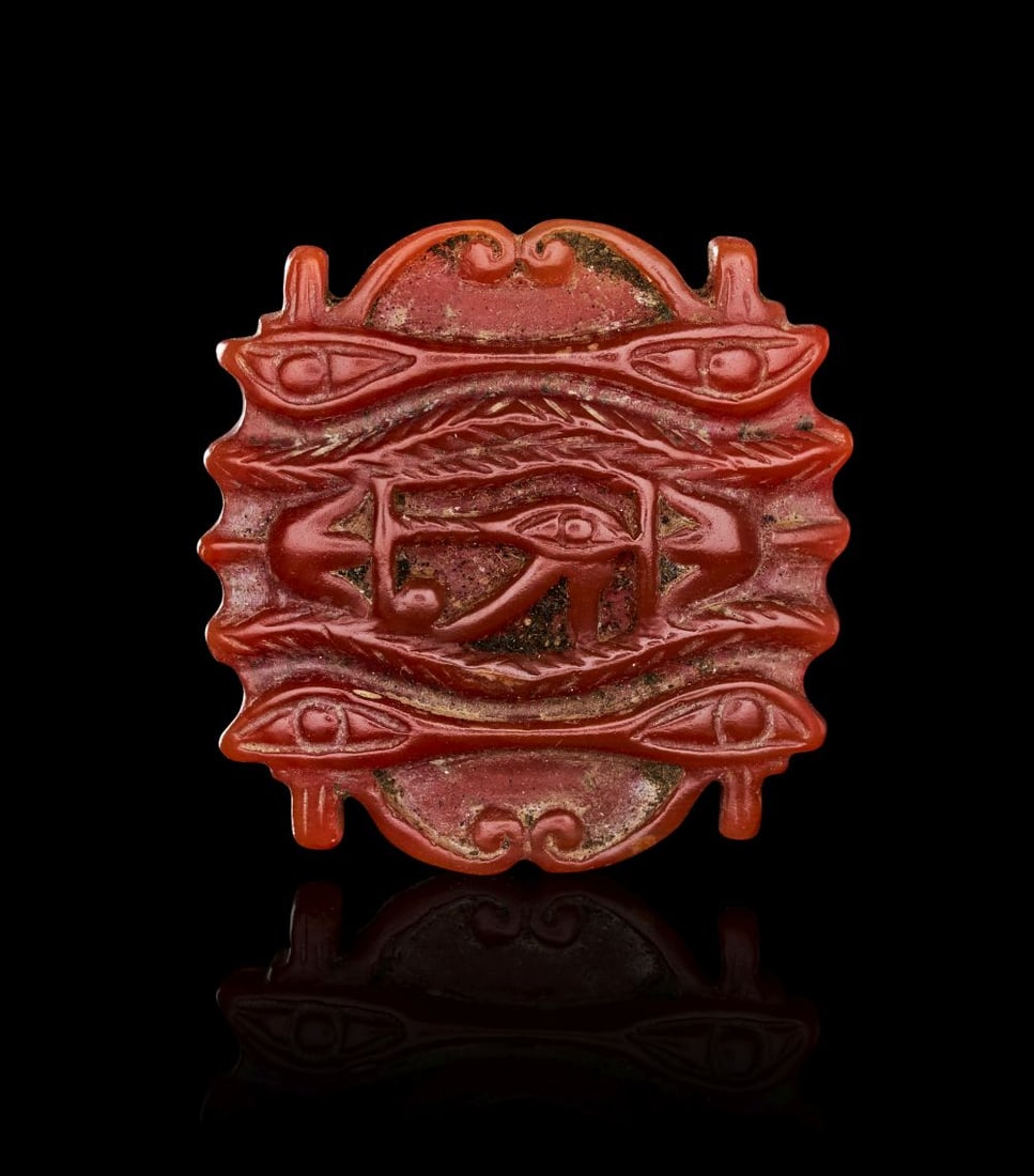 AN EGYPTIAN AGATE WEDJAT-EYE NEW KINGDOM, DYNASTY XIX, CIRCA 1279-1212 B.C. (1 of 2)