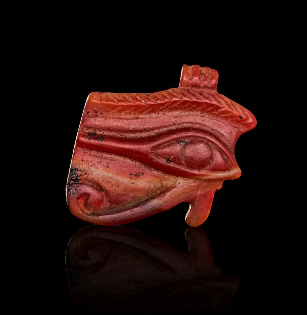 AN EGYPTIAN AGATE WEDJAT-EYE NEW KINGDOM, DYNASTY XIX, CIRCA 1279-1212 B.C. (1 of 2)