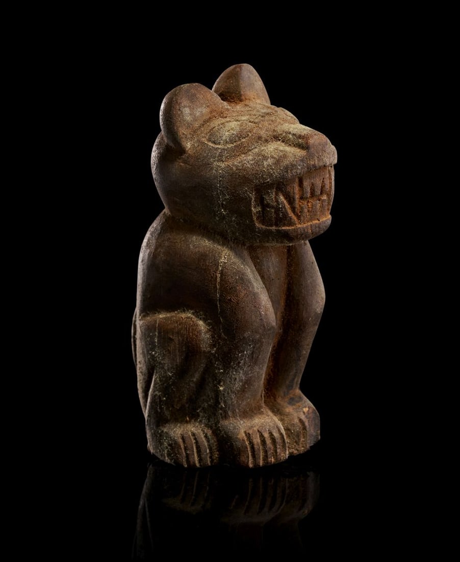 A PRE COLOMBIAN WOODEN CAT FIGURINE, CIRCA 800-1200 A.D: A PRE-COLUMBIAN WOODEN CAT FIGURINE, CIRCA 800–1200 A.D. Carved from a dense, dark hardwood and retaining a rich, time-softened surface, this compact feline figure is rendered with a striking
