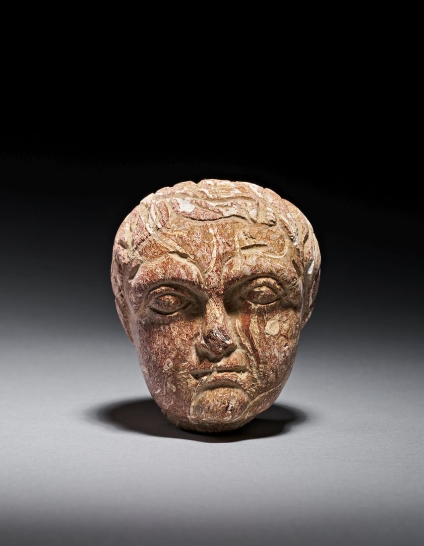 A LATE GREEK CARVED STONE HEAD OF A YOUTH, CIRCA 3RD CENTURY A.D. (1 of 5)