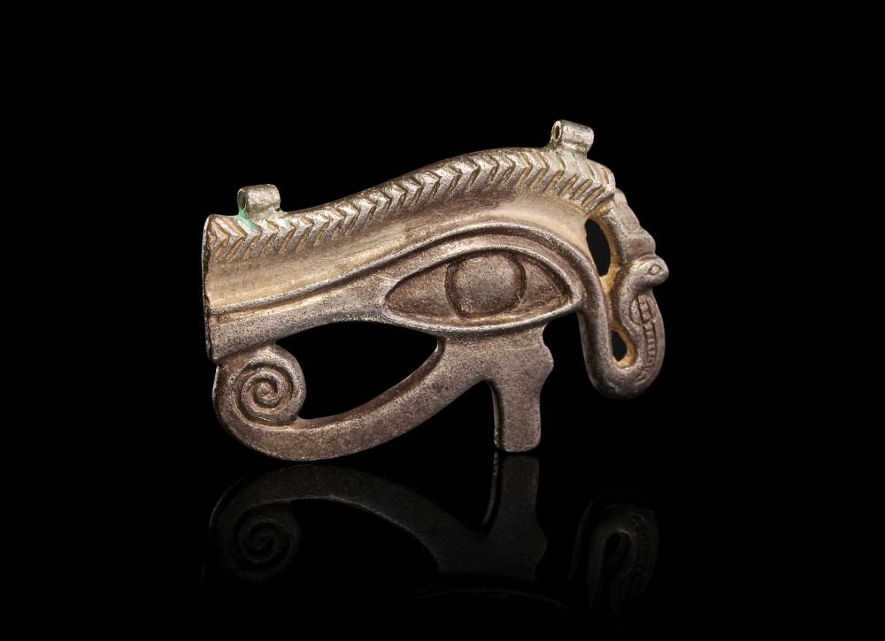 AN EGYPTIAN SILVER WEDJAT-EYE AMULET LATE PERIOD, DYNASTY XXVI-XXX, 664-343 B.C. (1 of 2)