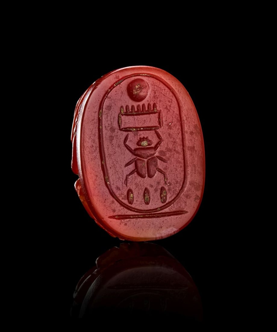 AN EGYPTIAN SCARAB CIRCA 2ND CENTURY B.C.: AN EGYPTIAN CARNELIAN SCARAB, CIRCA 2ND CENTURY B.C. Carved from a lustrous red carnelian of rich, saturated tone, this finely-modelled scarab presents a compact and powerfully sculptural form, its