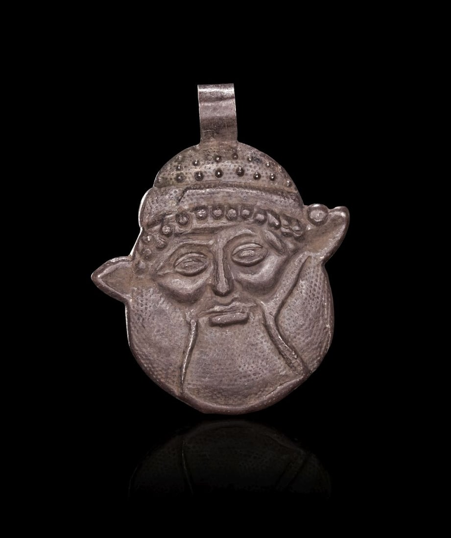 A SILVER ETRUSCAN FACE AMULET, CIRCA 650-600 B.C. (1 of 8)