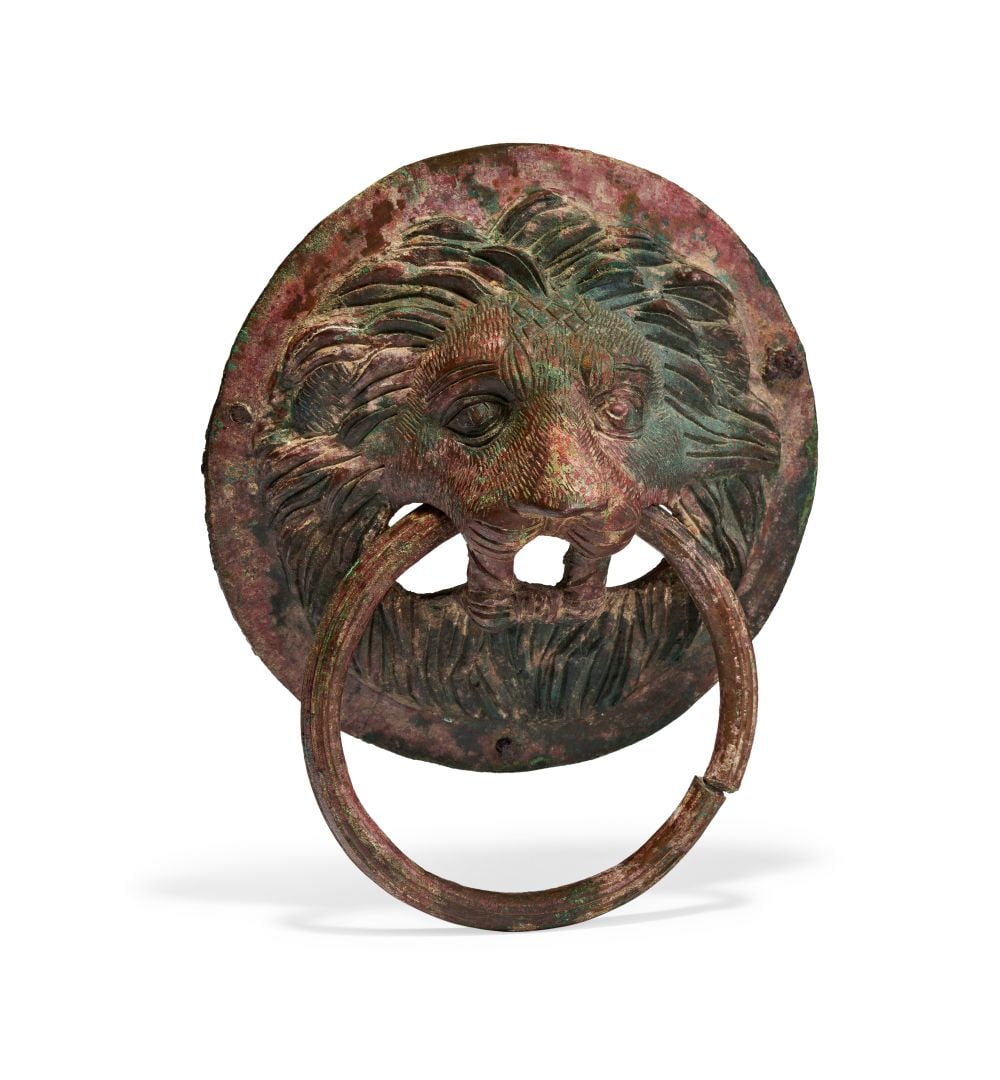 A LARGE ROMAN BROZNE LION HEAD DOOR KNOCKER, CIRCA 2ND CENTURY A.D.: A LARGE ROMAN BRONZE LION HEAD DOOR KNOCKER, CIRCA 2ND CENTURY A.D. Cast in substantial bronze and conceived with commanding sculptural force, this imposing door knocker takes the form of a leonine