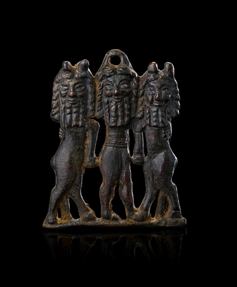 A BRONZE APPLIQUE DEPICTING THREE COURTLY WORSHIPPERS, BRONZE AGE, 11TH CENTURY B.C. (1 of 2)