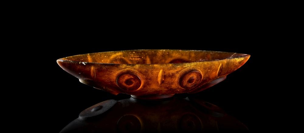 A POST SASANIAN CUT AMBER GLASS DISH IRAN, CIRCA 7TH CENTURY (1 of 3)