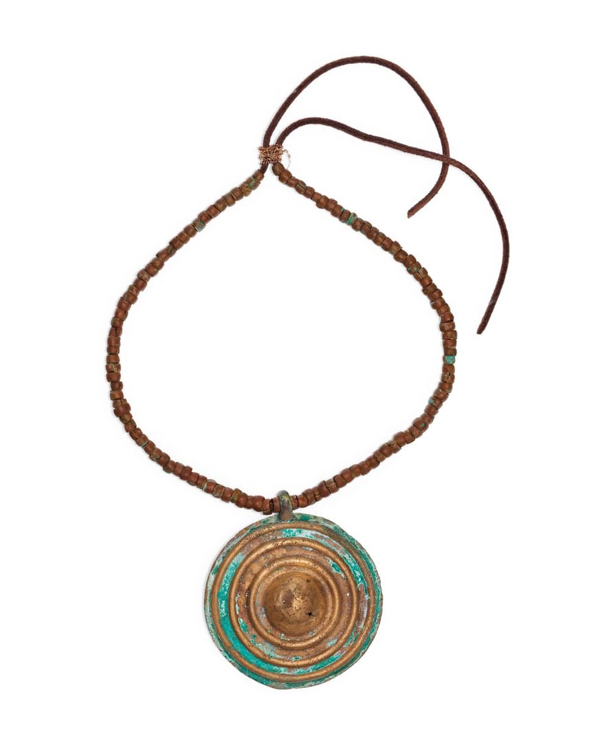 A LURISTAN COPPER DISC NECKLACE, CIRCA 9TH-7TH CENTURY: A LURISTAN COPPER DISC NECKLACE, CIRCA 9TH–7TH CENTURY B.C. Cast in copper and preserved with a richly variegated malachite patina, the necklace is centred on a bold, circular disc pendant of