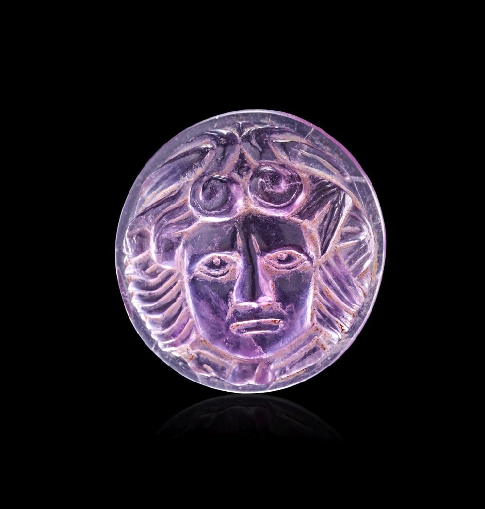 A GREEK AMETHYST CAMEO OF MEDUSA, 1ST CENTURY A.D. OR LATER: A GREEK AMETHYST CAMEO OF MEDUSA, 1ST CENTURY A.D. OR LATER Carved from a luminous amethyst of delicate yet richly saturated violet hue, this finely worked cameo presents the compelling visage of Me