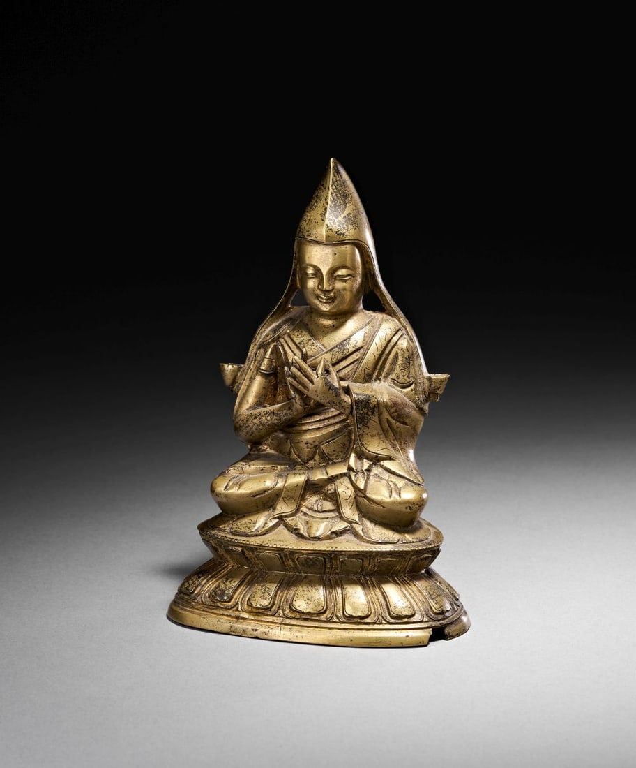 A GILT BRONZE FIGURE OF TSONGKHAPA TIBET, 17TH CENTURY: A GILT BRONZE FIGURE OF TSONGKHAPA TIBET, 17TH CENTURY Seated in vajraparyankasana upon a double-lotus base, this finely cast gilt bronze figure represents Tsongkhapa (1357–1419), the revered